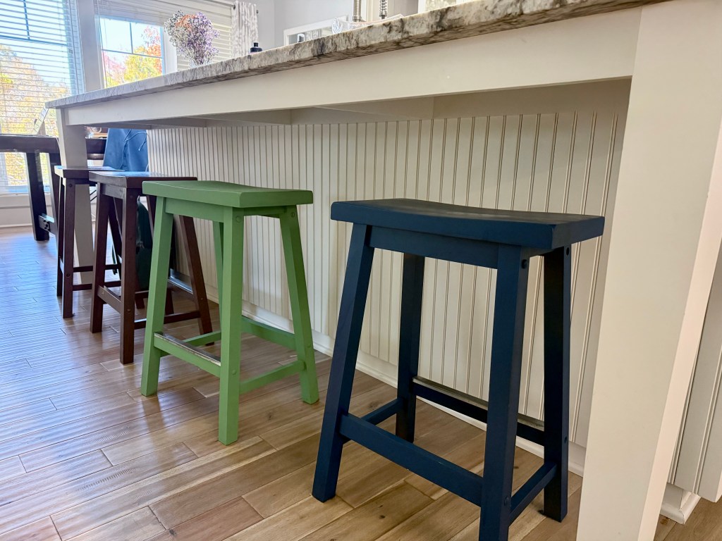 Mismatching bar stools in blue, green, and brown.